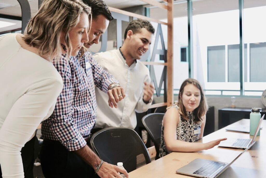 A team of individuals gathered around a laptop, deciding how to respond to an RFP.